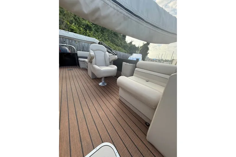 Slide: The Image of 2024 Bentley Pontoons Legacy 243 DL Navigator interior with plush seating and wood flooring. - 5