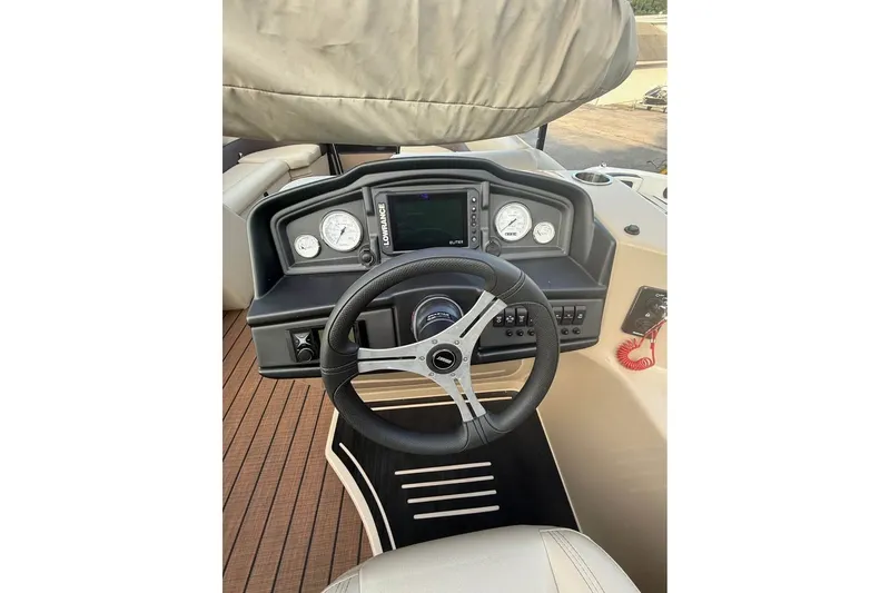Slide: The Image of 2024 Bentley Pontoons Legacy 243 DL Navigator dashboard with steering wheel and gauges. - 7