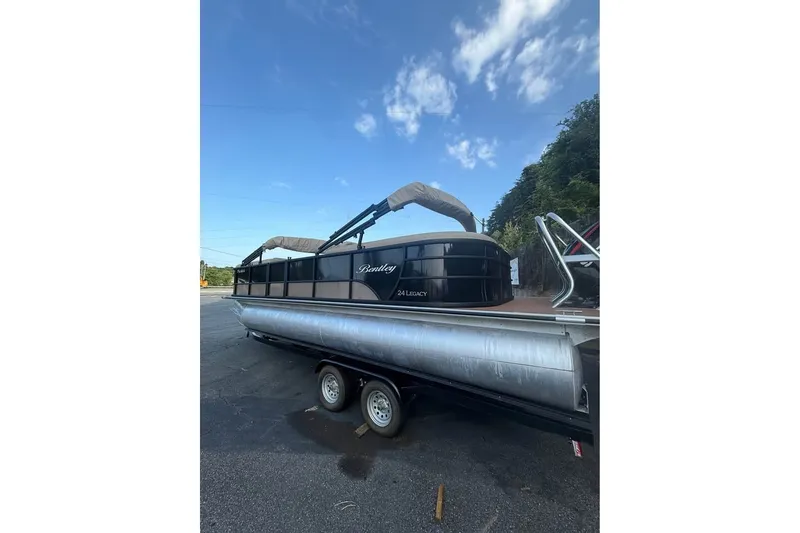 The Image of 2024 Bentley Pontoons Legacy 243 DL Navigator on trailer under blue sky. - 1