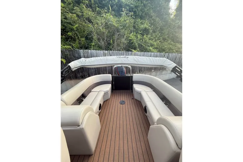 Slide: The Image of 2024 Bentley Pontoons Legacy 243 DL Navigator with luxurious seating and wooden deck. - 6