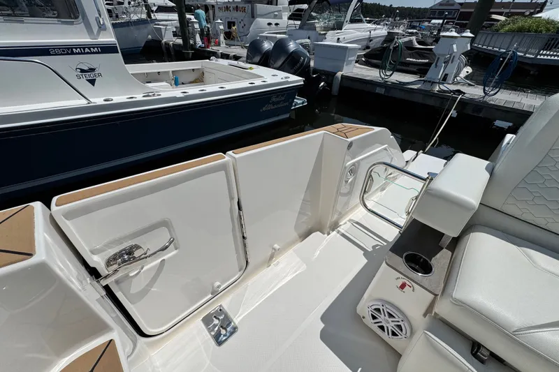 Slide: The Image of 2023 Tiara Yachts 43 LE boat interior with seating and storage compartments at a marina. - 35