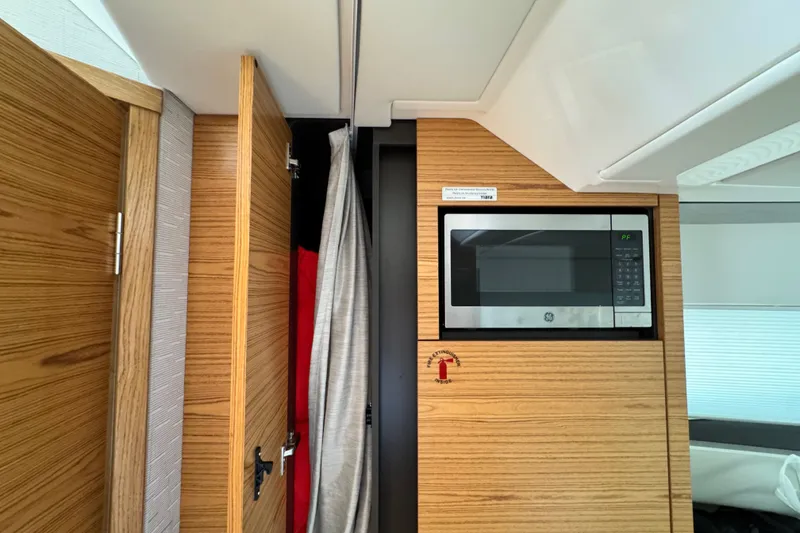 Slide: The Image of 2023 Tiara Yachts 43 LE interior with wood paneling and built-in microwave. - 38