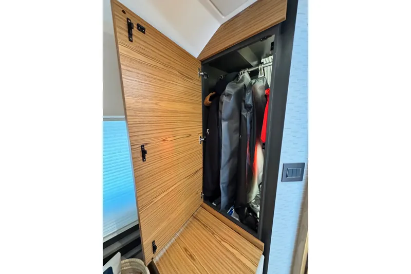 Slide: The Image of Wooden closet interior on 2023 Tiara Yachts 43 LE, showcasing hanging jackets. - 50