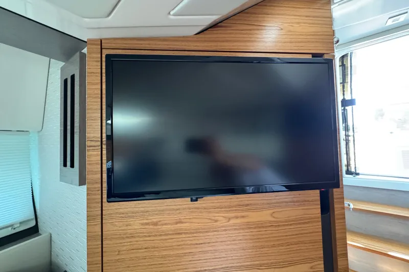 Slide: The Image of Flat-screen TV mounted on wood panel inside 2023 Tiara Yachts 43 LE. - 55