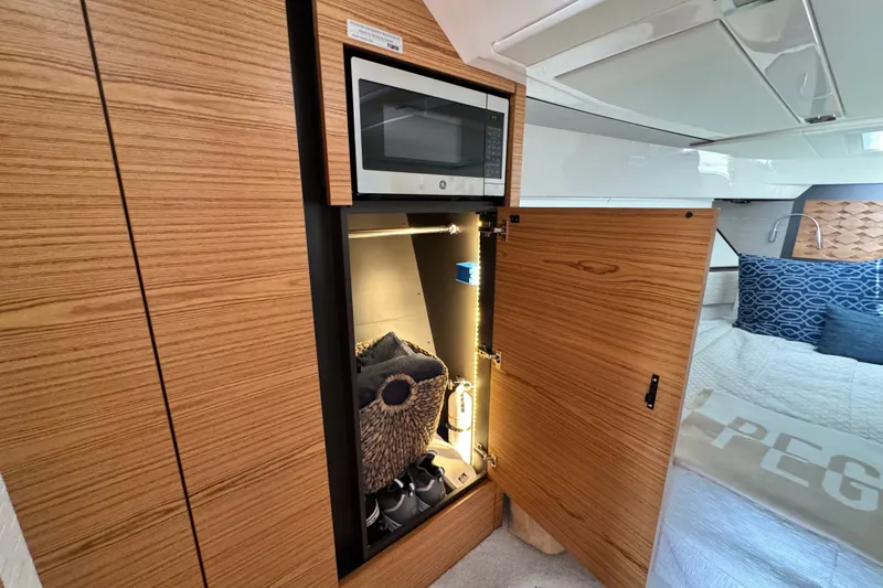 Slide: The Image of 2023 Tiara Yachts 43 LE interior with microwave and storage cabinet. - 39