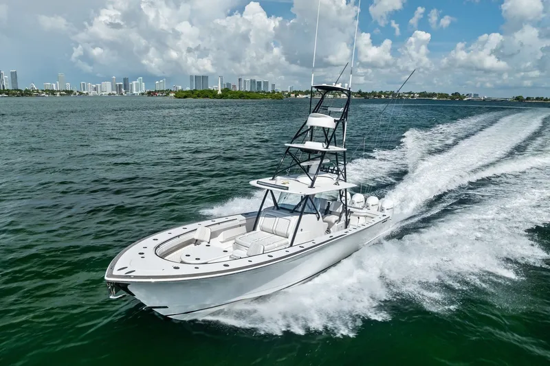 Slide: The Image of 2022 Valhalla V-41 boat cruising on open water with city skyline backdrop. - 21