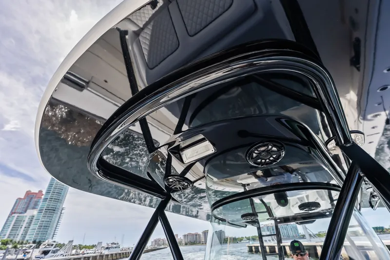 Slide: The Image of 2022 Valhalla V-41 boat with sleek black canopy and modern design at a marina. - 51