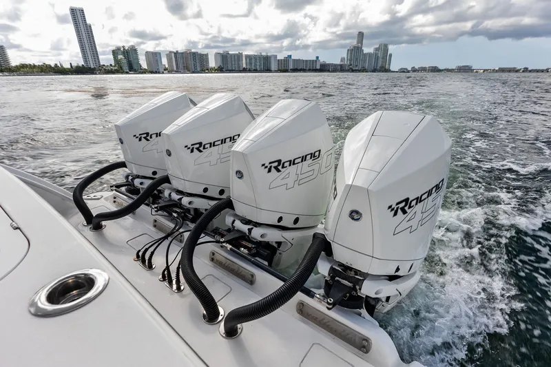 Slide: The Image of Four powerful outboard engines on a 2022 Valhalla V-41 boat, cruising near a city skyline. - 26