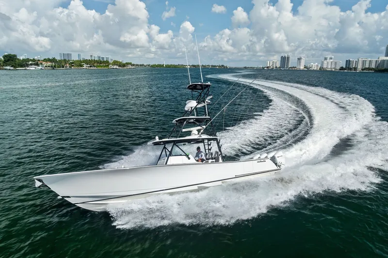 Slide: The Image of 2022 Valhalla V-41 boat cruising on a sunny day with city skyline in background. - 23