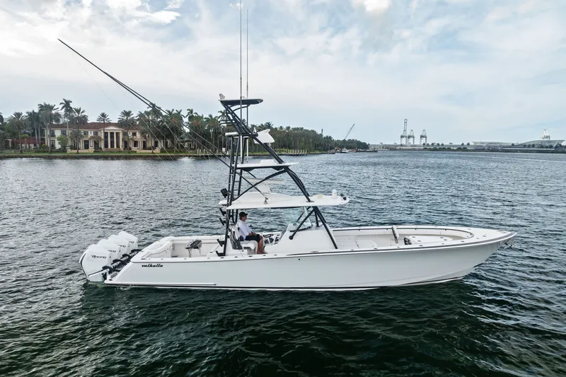 Slide: The Image of 2022 Valhalla V-41 boat cruising on a scenic waterway with luxury homes in the background. - 3