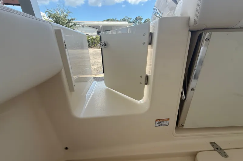 Slide: The Image of 2027 Scout 240 XSF boat interior with open compartment door, showcasing sleek design. - 14