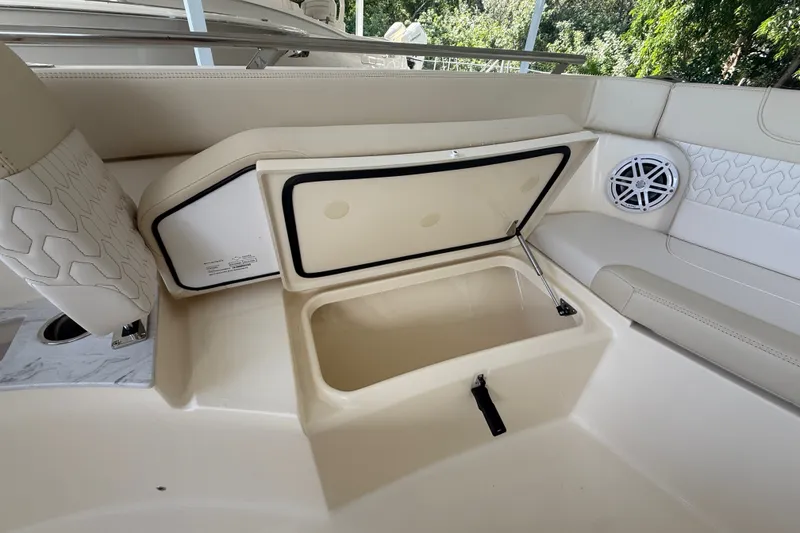 Slide: The Image of 2027 Scout 240 XSF boat interior storage compartment with open lid and speaker. - 2