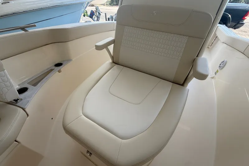 Slide: The Image of 2027 Scout 240 XSF boat interior with beige seating and armrests. - 5