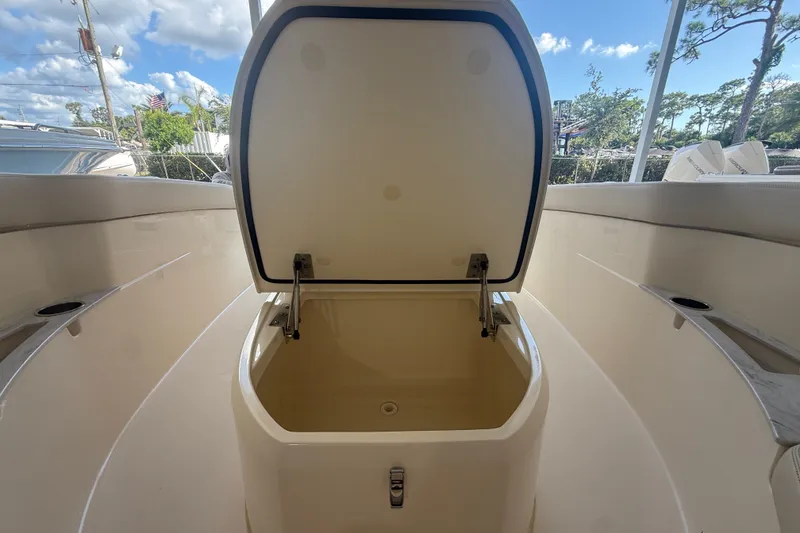 Slide: The Image of Open storage compartment on 2027 Scout 240 XSF boat under clear blue sky. - 6