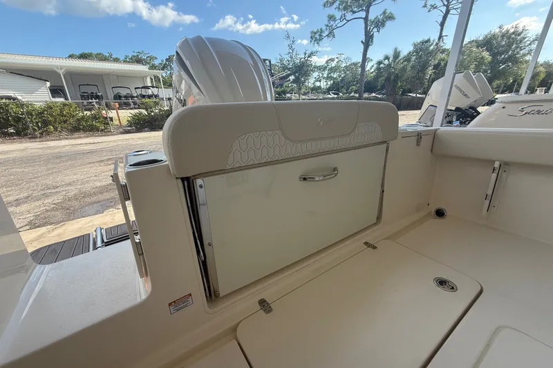 Slide: The Image of 2027 Scout 240 XSF boat interior with seating and storage, under a clear blue sky. - 12