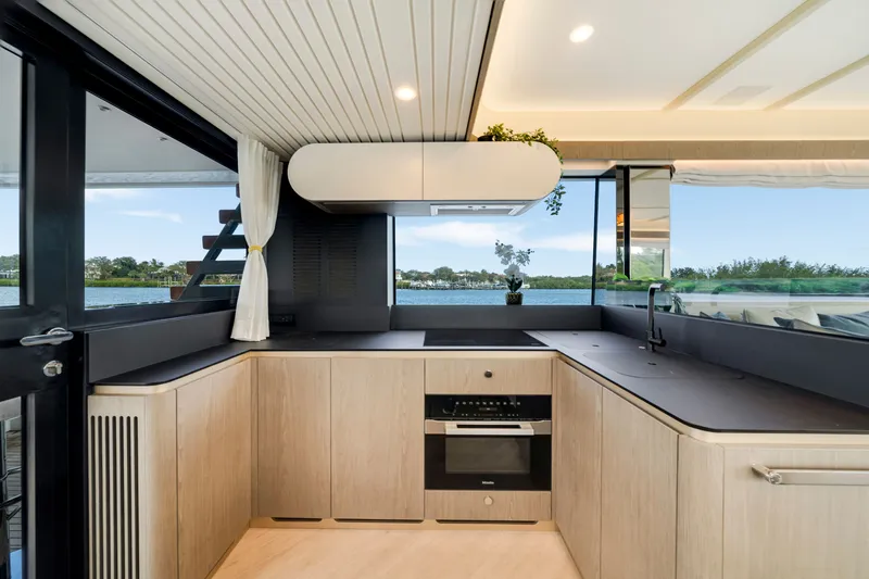 Slide: The Image of The kitchen of a 2024 Azimut Magellano with modern appliances and large windows overlooking the water. - 20