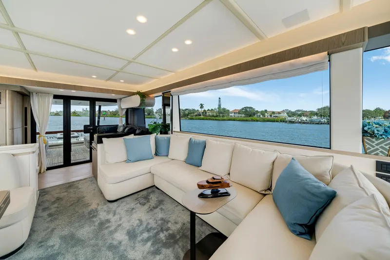 Slide: The Image of Interior of a luxury yacht with white sofas and blue cushions, overlooking the water. - 29