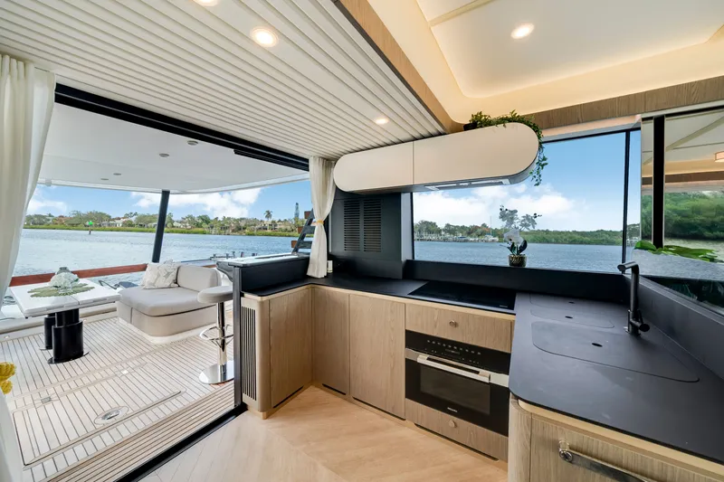 Slide: The Image of The 2024 Azimut Magellano features a modern kitchen overlooking the water and a stylish lounge area. - 19