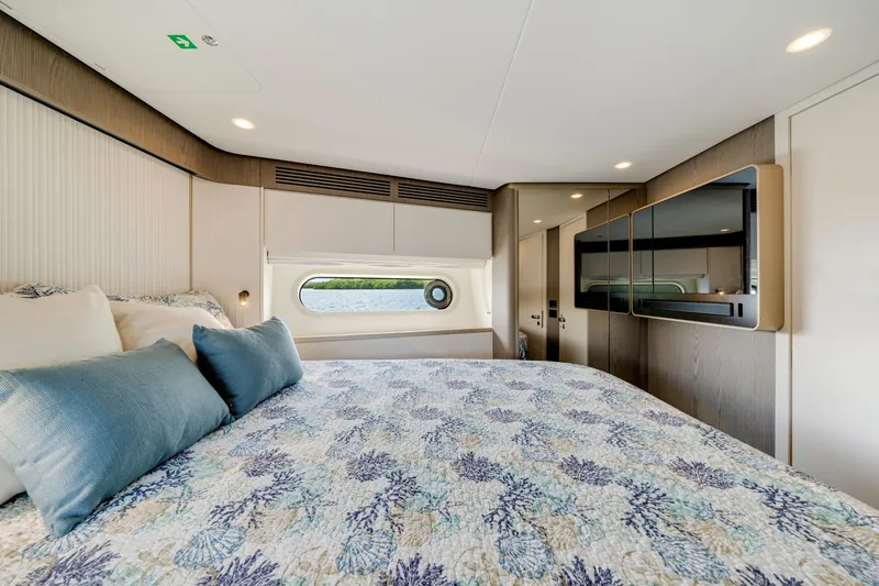 Slide: The Image of Luxurious cabin with a large bed, window, and modern decor on an Azimut Magellano 2024. - 37