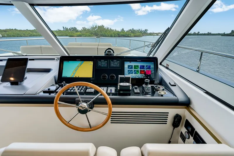 Slide: The Image of The cockpit of the 2024 Azimut Magellano features modern navigation instruments and a panoramic view of the water. - 27