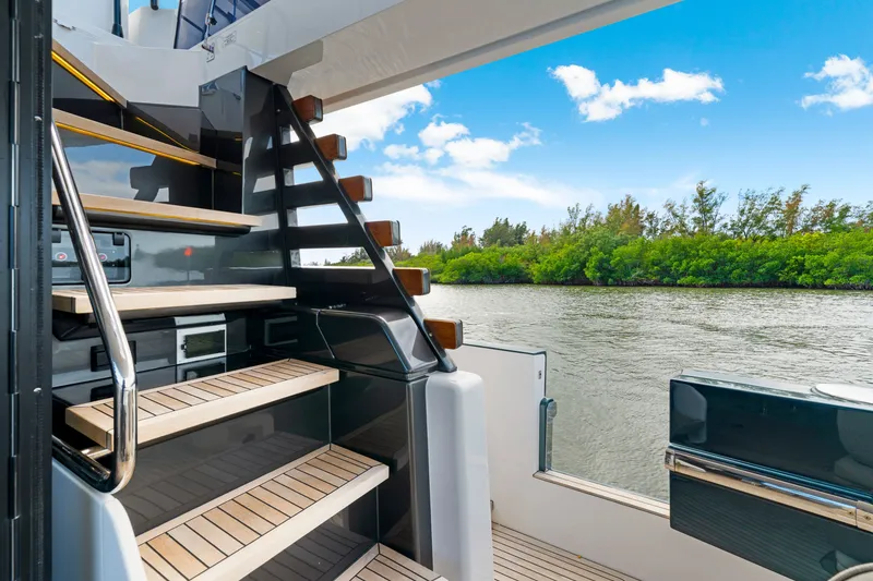 Slide: The Image of The staircase on the 2024 Azimut Magellano leads to an elegant deck overlooking the water. - 17
