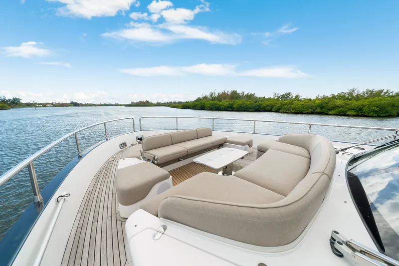 Slide: The Image of The 2024 Azimut Magellano features an elegant deck with comfortable seating and a table, surrounded by water and trees. - 41