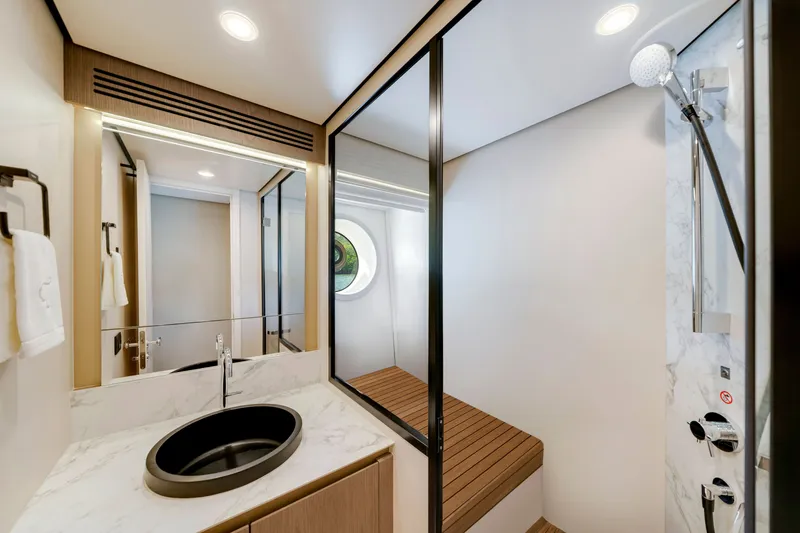 Slide: The Image of Modern bathroom with round sink, wooden bench, and shower in an Azimut Magellano 2024. - 40