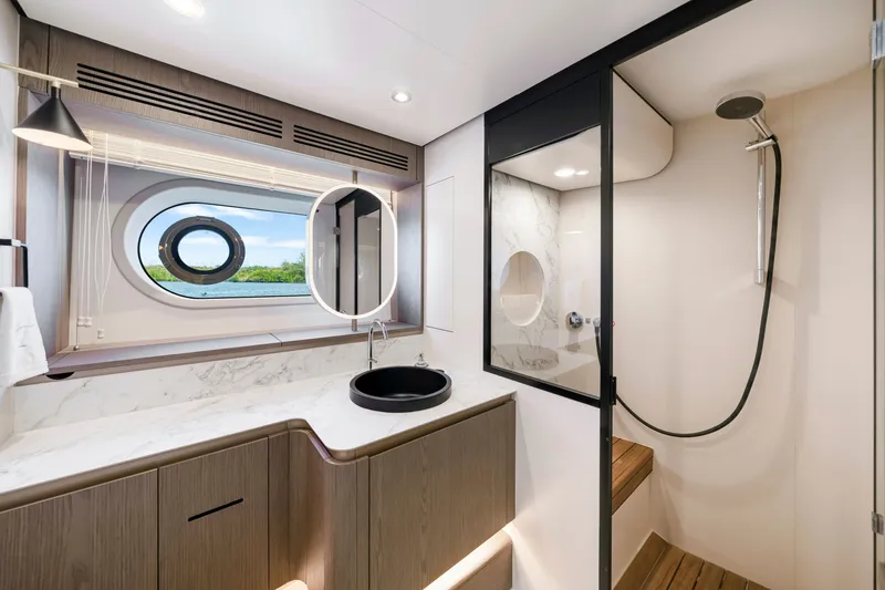 Slide: The Image of Luxurious bathroom on an Azimut Magellano 2024 with modern sink, shower, and porthole. - 34
