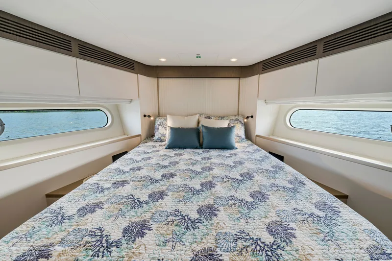 Slide: The Image of The image shows a luxurious bedroom on a 2024 Azimut Magellano yacht with large windows. - 36