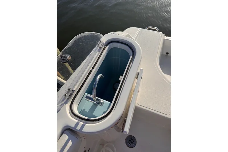 Slide: The Image of Livewell on 2023 Wellcraft 242 Fisherman boat, open lid, near water. - 86