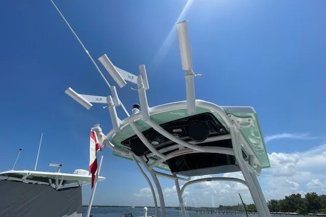 Slide: The Image of 2023 Wellcraft 242 Fisherman boat with radar and antennas under a clear blue sky. - 30