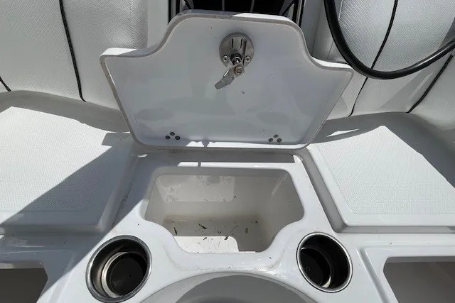 Slide: The Image of 2023 Wellcraft 242 Fisherman boat interior with open storage compartment and cup holders. - 66