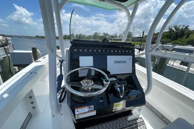 Slide: The Image of 2023 Wellcraft 242 Fisherman boat dashboard with steering wheel and Simrad navigation system. - 32