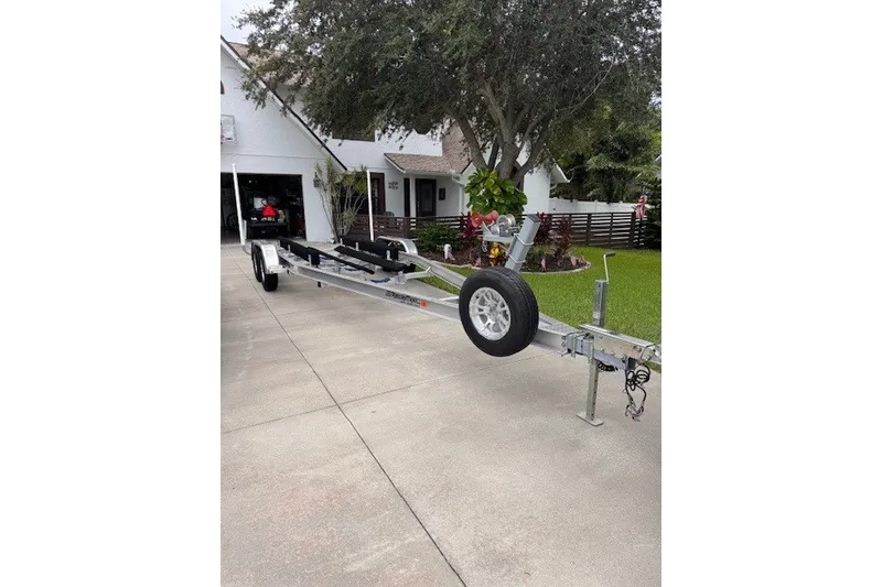 Slide: The Image of Trailer for 2023 Wellcraft 242 Fisherman boat parked in a driveway. - 1
