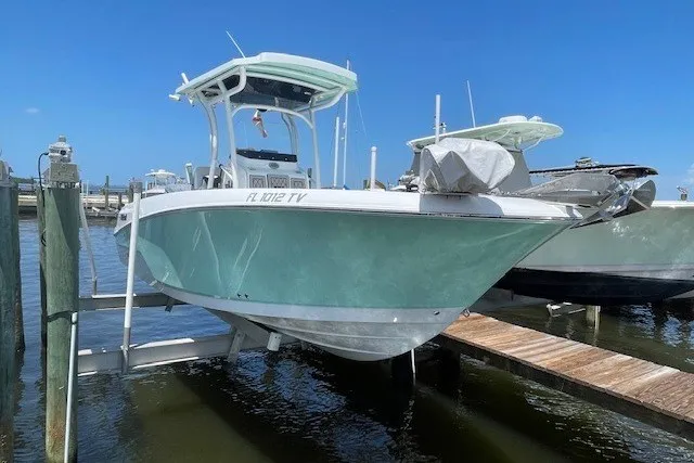 Slide: The Image of 2023 Wellcraft 242 Fisherman boat docked at marina, clear blue sky background. - 2