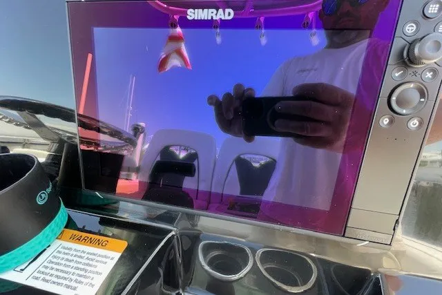 Slide: The Image of Simrad display on 2023 Wellcraft 242 Fisherman boat dashboard, reflecting surroundings. - 39