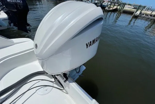 Slide: The Image of 2023 Wellcraft 242 Fisherman boat with Yamaha outboard motor docked by the water. - 6