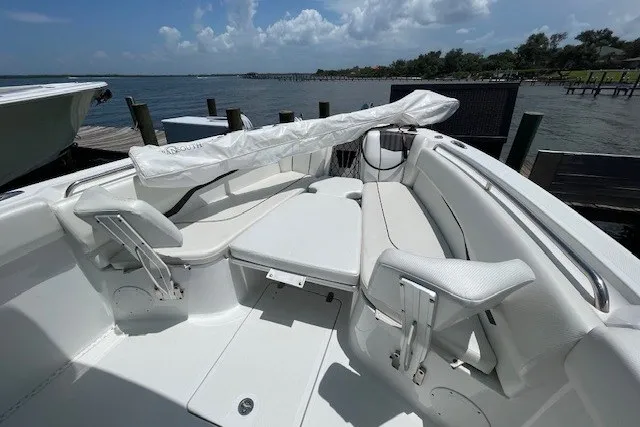 Slide: The Image of 2023 Wellcraft 242 Fisherman boat interior with white seating, docked by the water. - 85