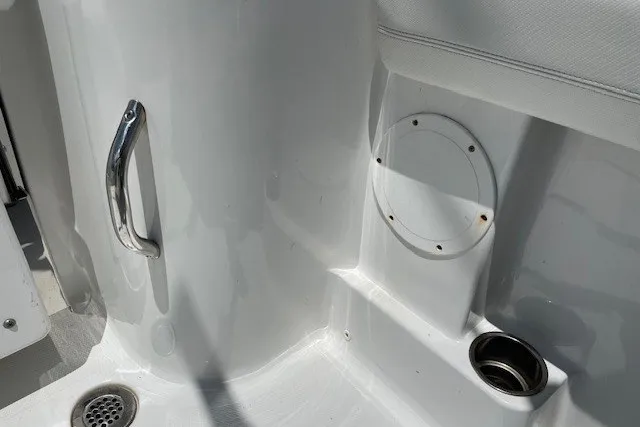Slide: The Image of Interior detail of 2023 Wellcraft 242 Fisherman boat, featuring sleek white surfaces and stainless steel fixtures. - 74