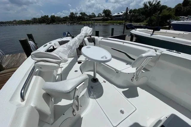 Slide: The Image of 2023 Wellcraft 242 Fisherman boat interior with seating and table, docked by the water. - 78