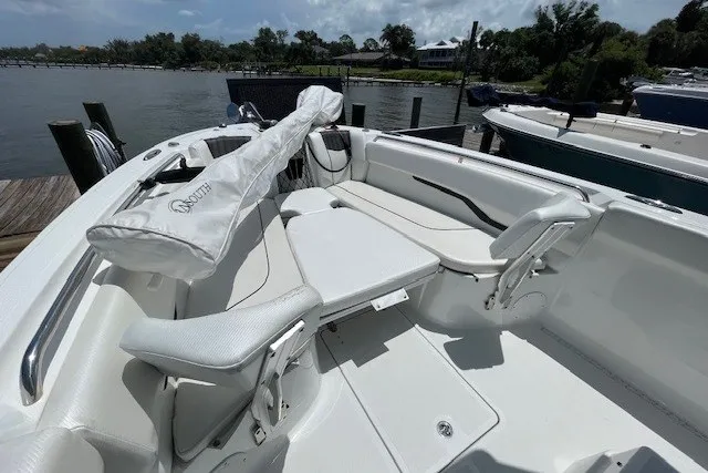 Slide: The Image of 2023 Wellcraft 242 Fisherman boat interior with seating and covered equipment, docked by the water. - 84