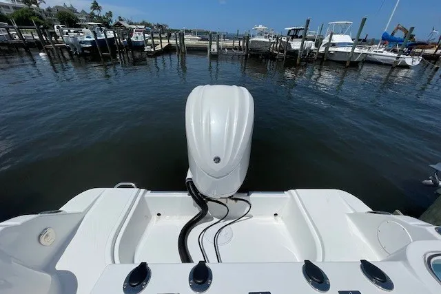 Slide: The Image of 2023 Wellcraft 242 Fisherman boat docked, showcasing rear engine and spacious deck. - 4