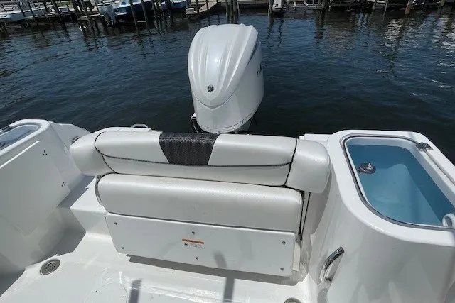 Slide: The Image of 2023 Wellcraft 242 Fisherman boat with outboard motor and seating, docked by the water. - 11