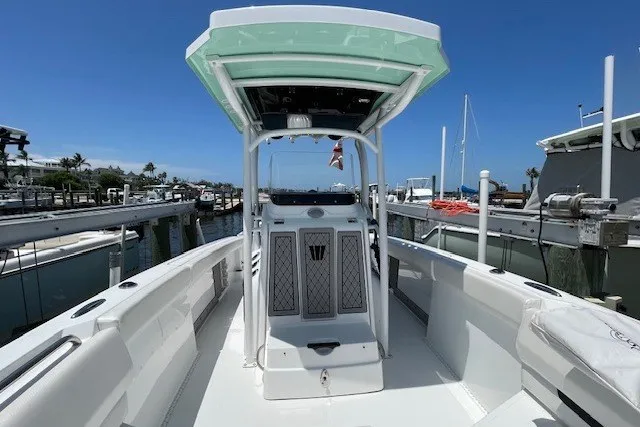 Slide: The Image of 2023 Wellcraft 242 Fisherman boat docked, showcasing sleek design and spacious deck. - 45