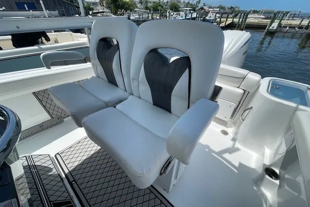 Slide: The Image of 2023 Wellcraft 242 Fisherman boat seats, featuring sleek white and black design, dockside view. - 33