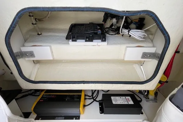 Slide: The Image of 2023 Wellcraft 242 Fisherman boat electrical compartment with wiring and battery components. - 60