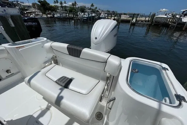 Slide: The Image of 2023 Wellcraft 242 Fisherman boat with seating and motor at a marina dock. - 15