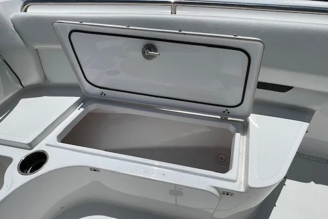 Slide: The Image of Open storage compartment on 2023 Wellcraft 242 Fisherman boat, featuring sleek white interior design. - 64