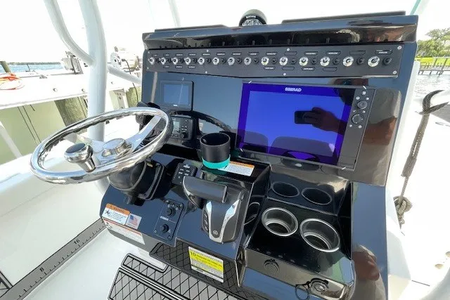 Slide: The Image of 2023 Wellcraft 242 Fisherman boat dashboard with steering wheel and electronic controls. - 26