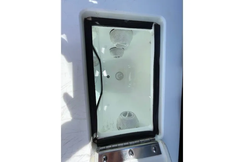 Slide: The Image of 2023 Wellcraft 242 Fisherman boat compartment with secure latch and rubber seal. - 76